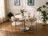 Q & P Furniture beige velvet dining table with silver accents, stylish for modern dining rooms, shown in a lifestyle setting.